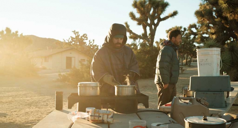 a person cooks over a stove in Joshua Tree National Park